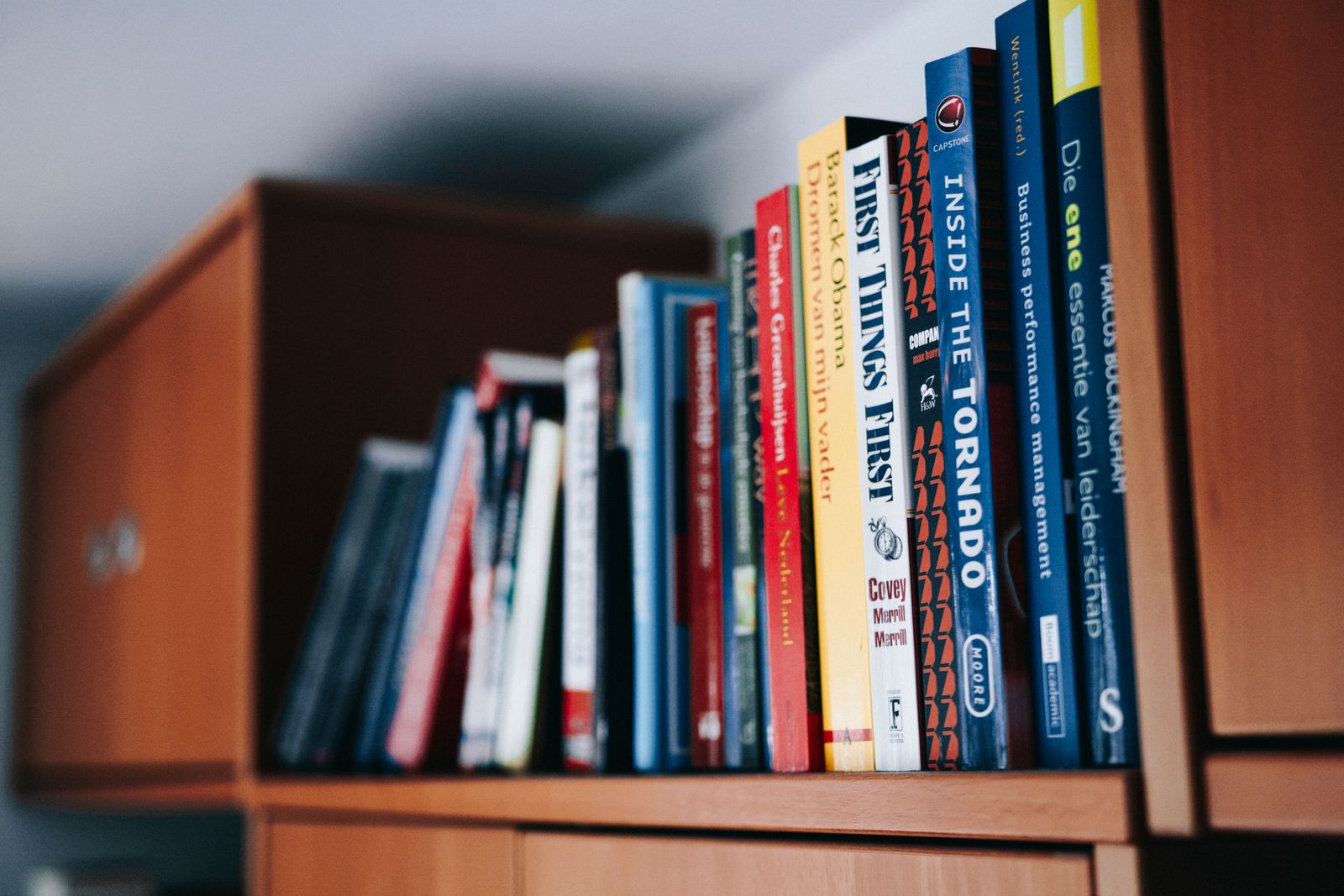 A close view of books arranged on a wooden shelf