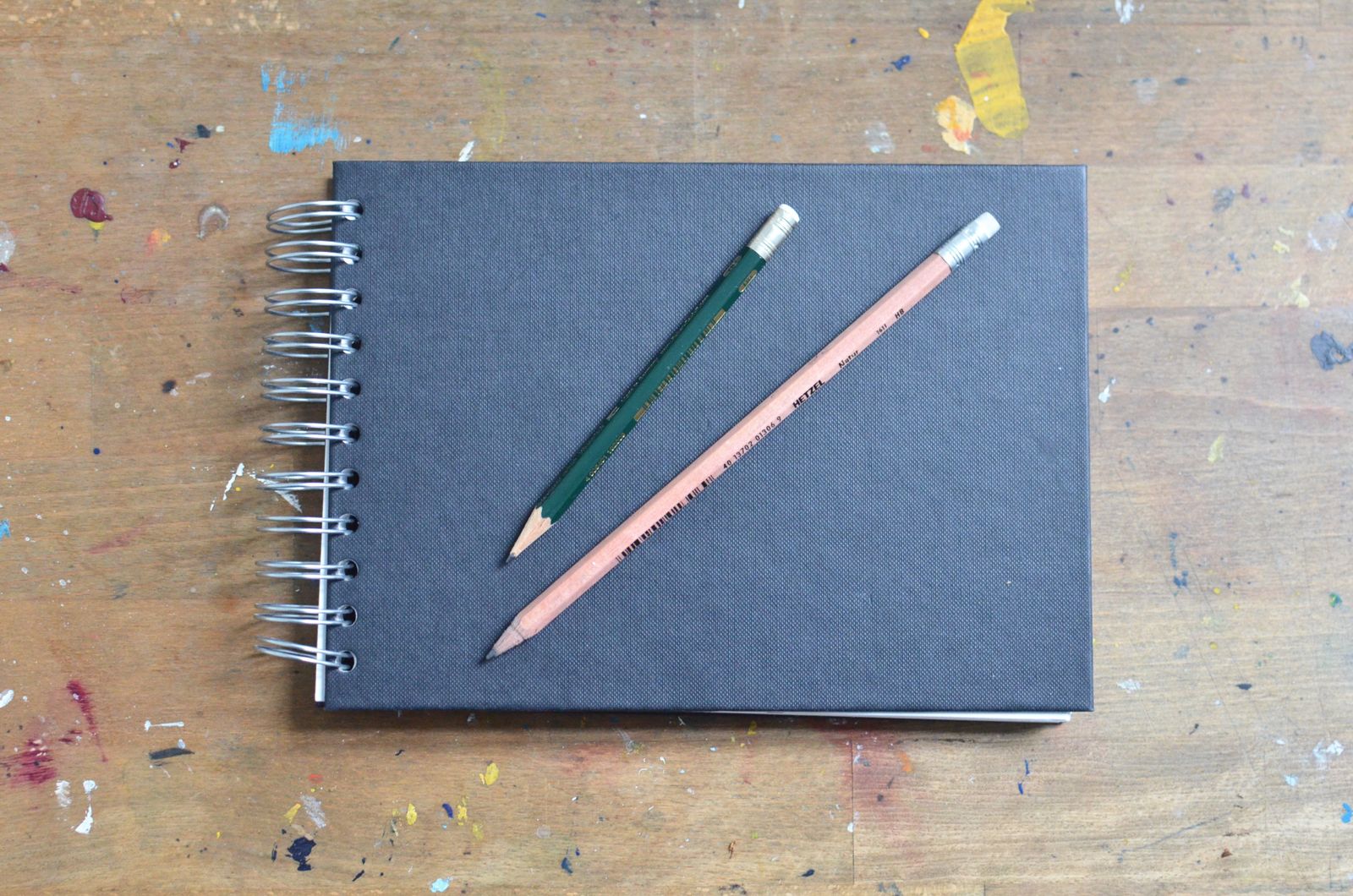 A plain notebook and pencil on a wooden table