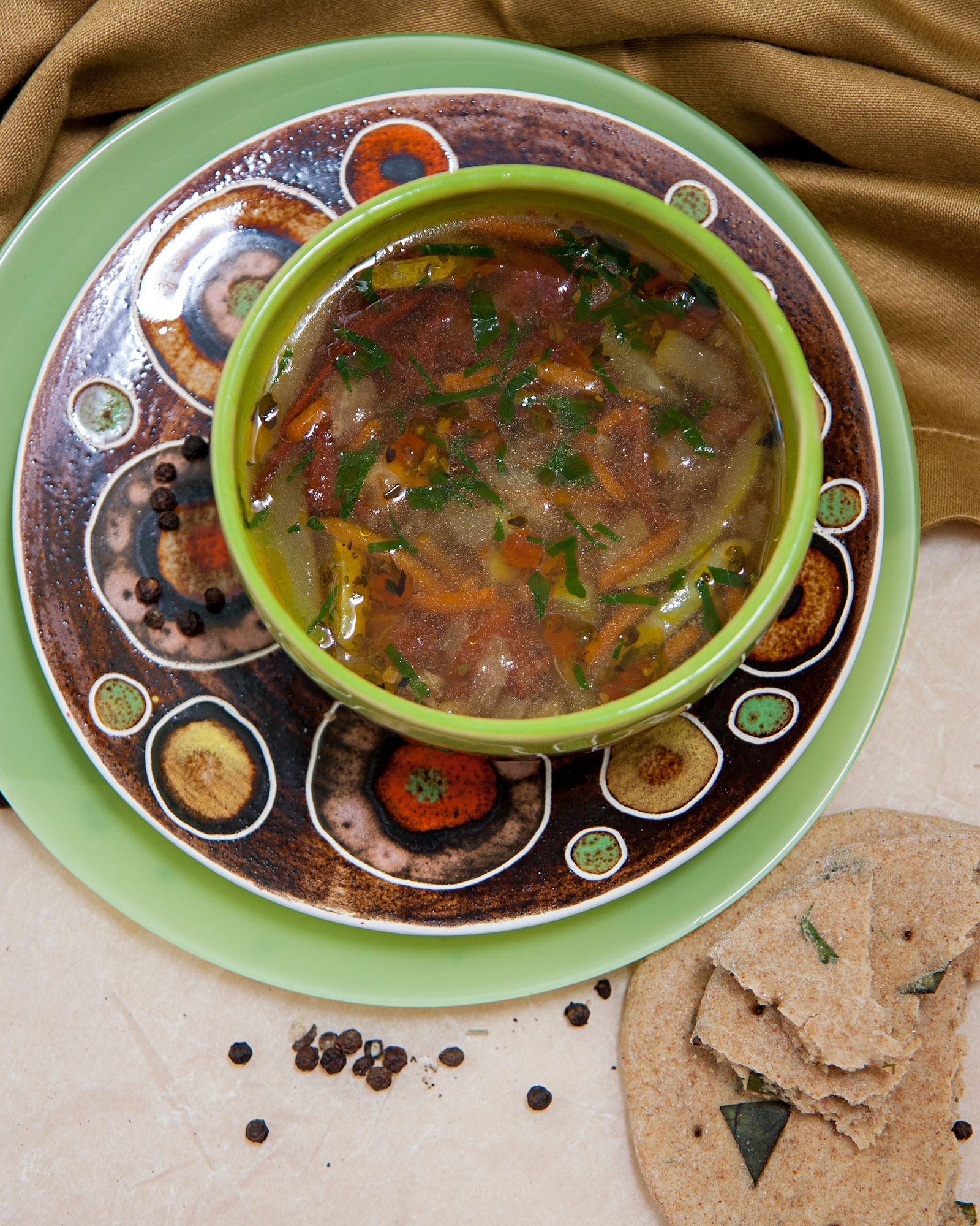 A bowl of vegetable and bean soup on a plain table